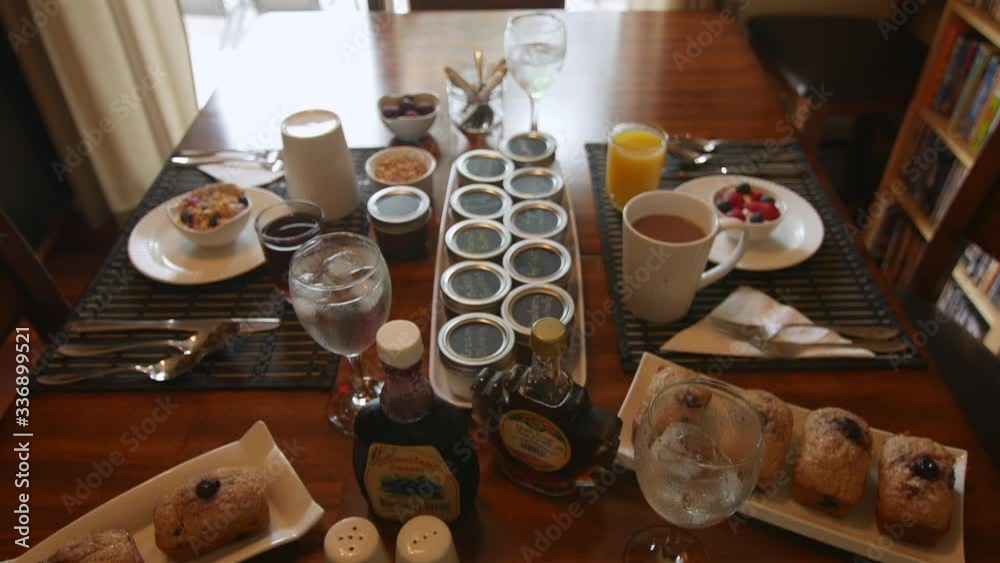 Jib shot of a neatly arranged breakfast table with muffins, grenola and coffee Jib shot of a neatly arranged breakfast table with muffins, grenola and coffee