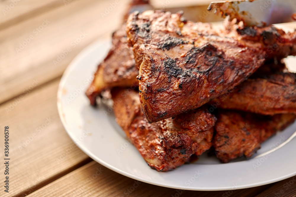 cooking, culinary and food concept - close up of grilled barbecue meat stack on plate