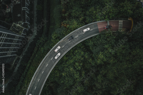 Aerial overhead drone shot of elevated road among jungles with traffic in Chongqing, China