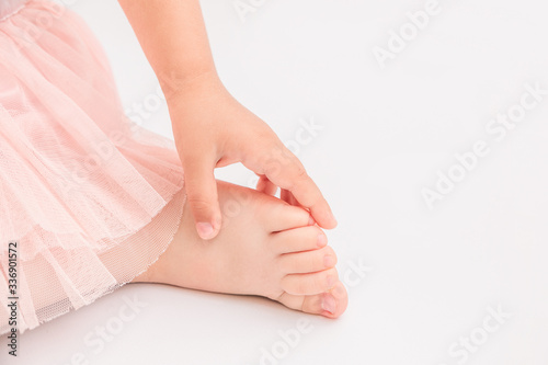 Feet of lovely little girl with flowers.White background
