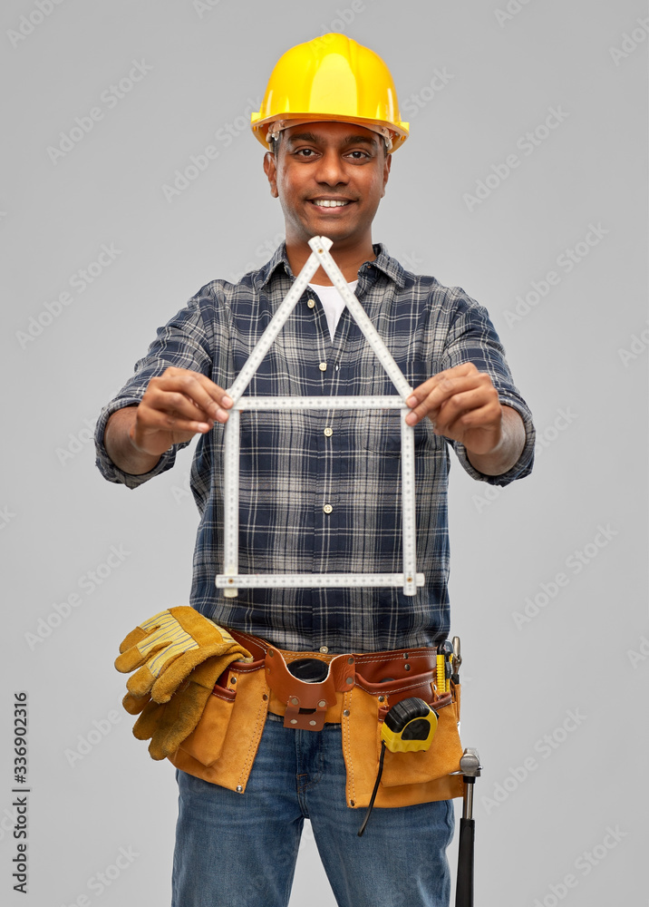 measurement, construction and building - happy smiling indian worker or builder in helmet with folding ruler in shape of home over grey background measurement, construction and building - happy smiling indian worker or builder in helmet with folding ruler in shape of home over grey background