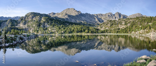 Paisaje las montañas de los pirineos de Andorra reflejado en el agua de un estanque.