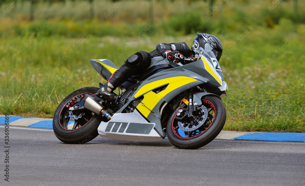 Motorcycle practice leaning into a fast corner on track Motorcycle practice leaning into a fast corner on track