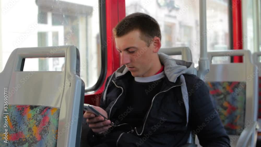 one young guy rides trams,young man goes on public transport quarantines, reads news about the epidemic in transport