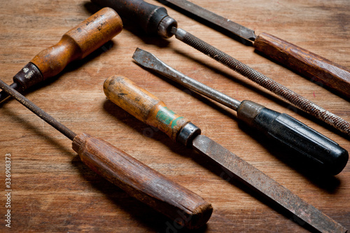 Old vintage screwdrivers and files of the last century extracted from the chest in the workshop of grandfather. Background for craftsmanship and manual labor.
