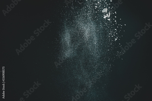 Wonderful pattern of white powder of light snow and flour explodes on black background