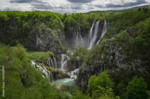Panoramic view of the biggest waterfall called veliki slap in plitvice lakes, croatia on a cloudy spring day. Big waterfall surrounded by lush greens in springtime.