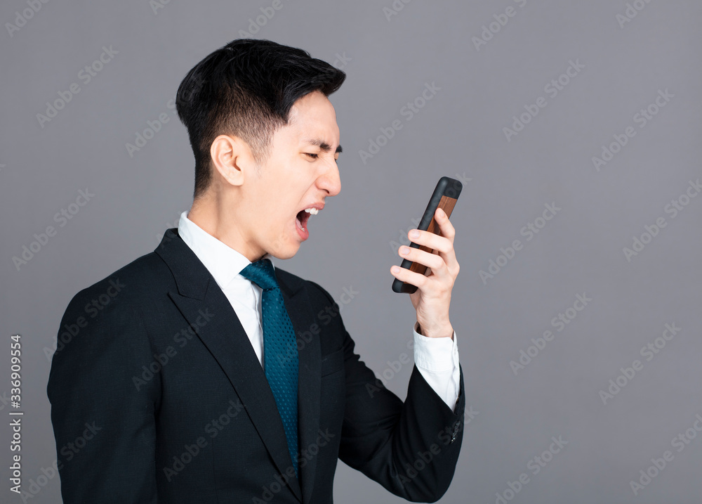 Angry business man screaming on mobile phone Angry business man screaming on mobile phone