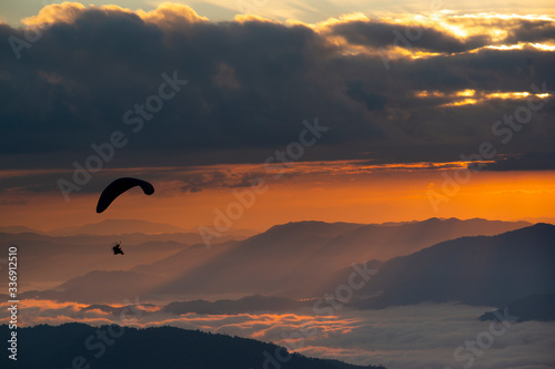 Paragliding at sunrise in the thailand mountains.