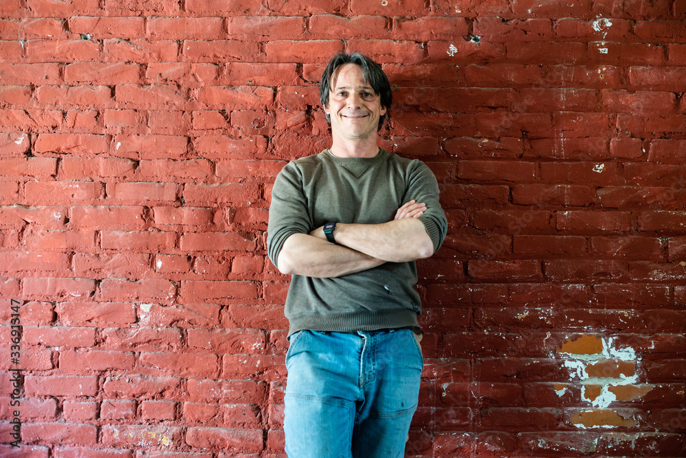 portrait of 45 year old worker man with red brick background portrait of 45 year old worker man with red brick background