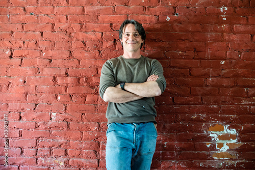 portrait of 45 year old worker man with red brick background
