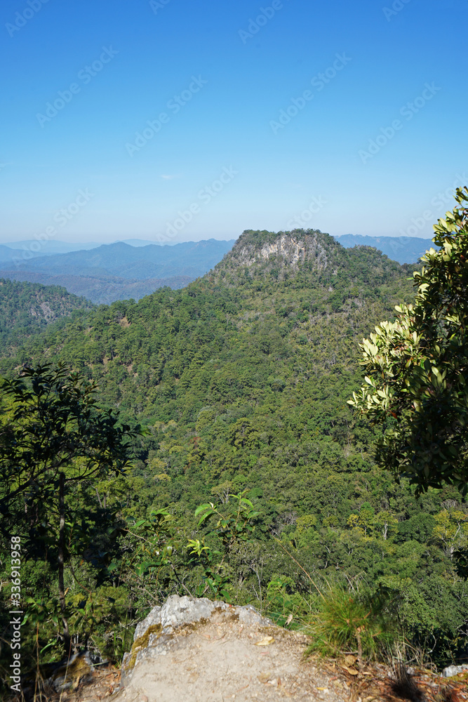 Natural landscape of rocky green mountain range view with clear blue sky