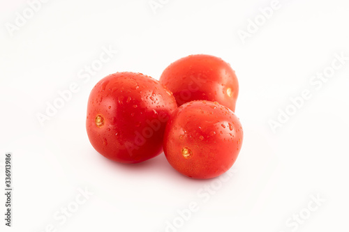 Fresh tomatoes with drops on a white background. Tomatoes with full depth of coldness