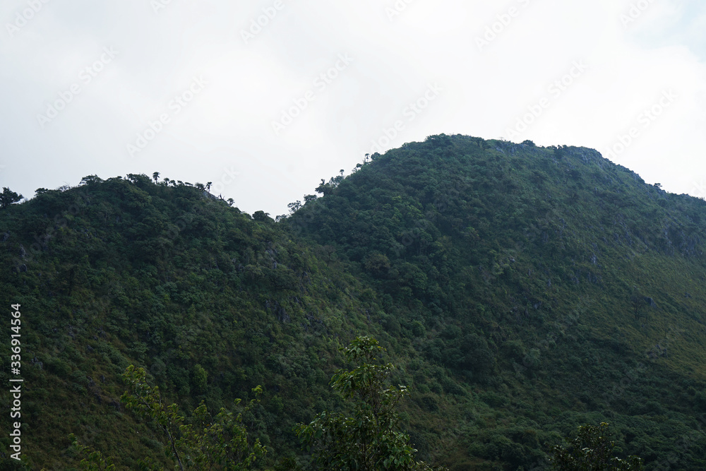 Natural landscape of green mountain range with cloudy blue sky Natural landscape of green mountain range with cloudy blue sky