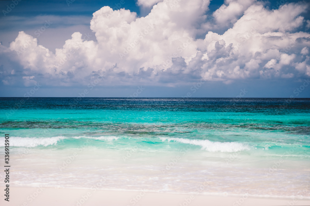 Sandy beach, blue ocean and white cloudscape at Mahe island, Seychelles Sandy beach, blue ocean and white cloudscape at Mahe island, Seychelles