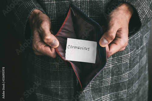 male hands holding an empty wallet without money with incription coronavirus  photo