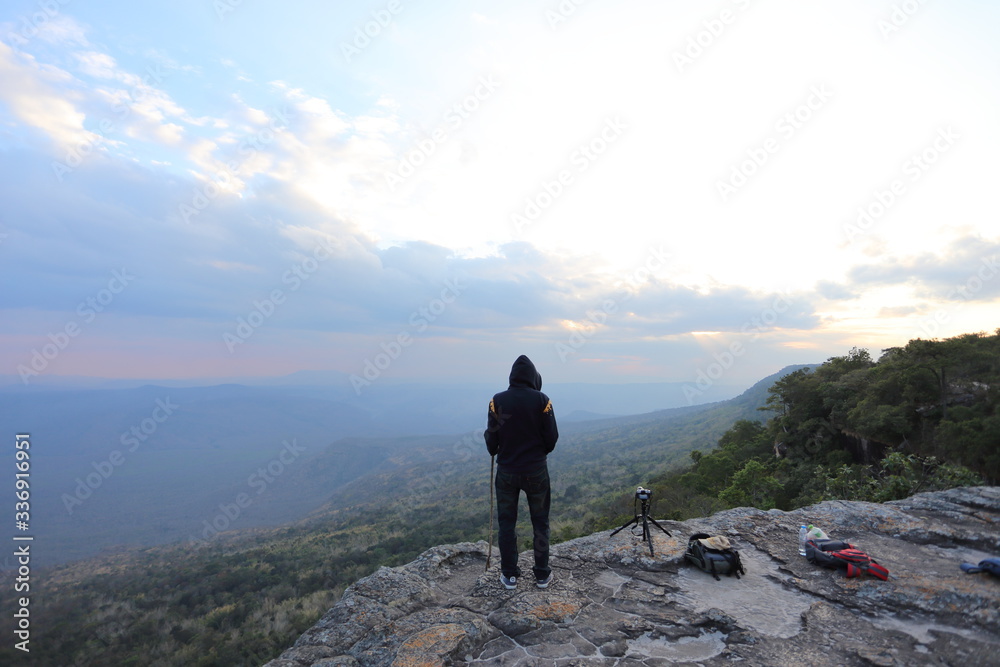 Man standing on the cliff, waiting for sunset pictures. Man standing on the cliff, waiting for sunset pictures.