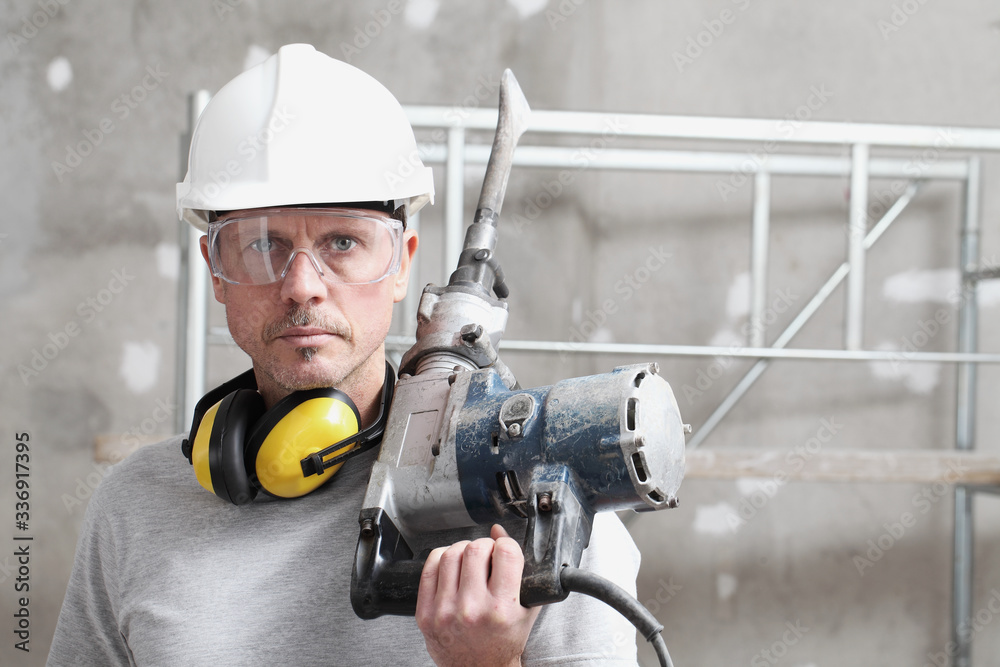 portrait of man construction worker with jackhammer with safety hard