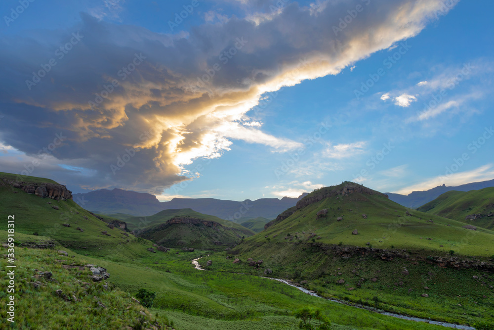 Yellow colored cloud at sunset over green valley Yellow colored cloud at sunset over green valley