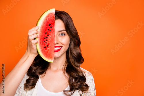 Photo of cheerful positive nice cute charming pretty girlfriend smiling toothily looking into camera with face half hidden with weage of weatermelon isolated over vivid color background