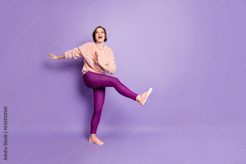 Full size photo of pretty lady dancing strange modern moves disco party students chilling raise one leg excited wear casual stylish pullover pants isolated purple color background Full size photo of pretty lady dancing strange modern moves disco party students chilling raise one leg excited wear casual stylish pullover pants isolated purple color background