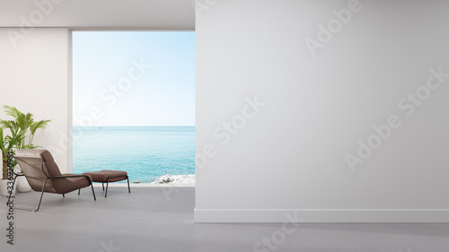 Armchair on concrete floor of large living room in modern house or luxury hotel. Minimal home interior 3d rendering with beach and sea view.