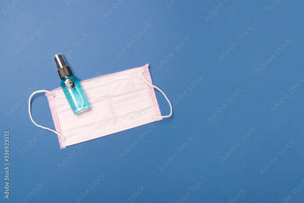 Medical face mask and sanitizer on blue background with copy space Medical face mask and sanitizer on blue background with copy space