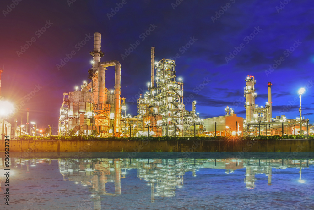 Oil refinery plant or power plant at dust with twilight and water reflection