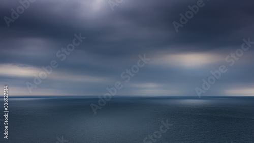 Obraz na płótnie Looking out to the ocean horizon from St Alban's Head as the sun tried to break through the dark clouds, Dorset, UK w salonie