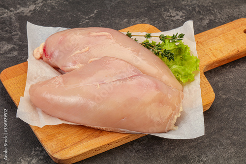 Raw chicken breast over board