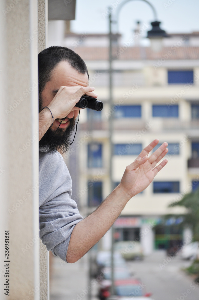 Young man waving family while he is leaning out of condominium window