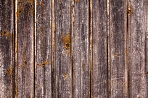 Vintage brown wood background texture with knots and nail holes. Old painted wood wall. Brown abstract background. Vintage wooden dark horizontal boards. Front view with copy space. 