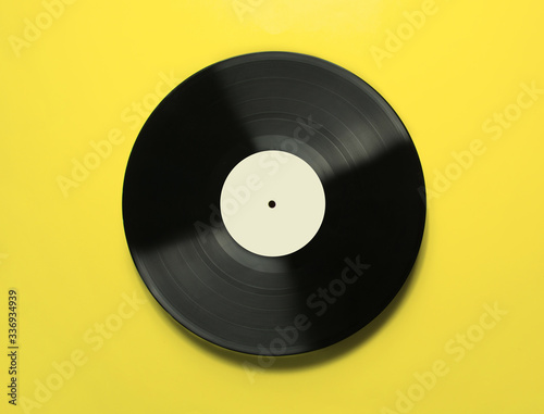 Vinyl record on a yellow background.Old vintage vinyl record