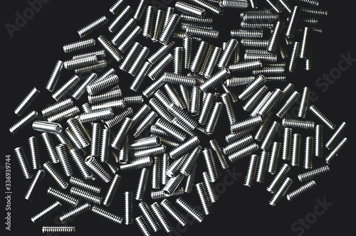 pile of steel screws on black background