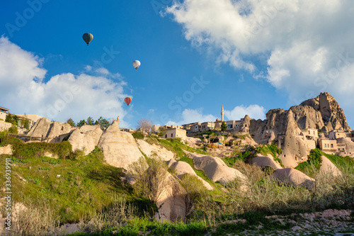 Uchisar Old Town is a limestone mountain, with houses and balloons in the morning in Cappadocia, Turkey. This spot is popular with tourists.