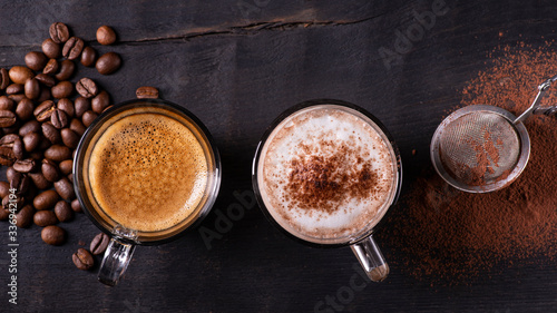 top view, close-up, on the dark wooden background, some types of espresso-based drinks, latte macchiato and cappuccino with a sprinkling of cocoa powder.