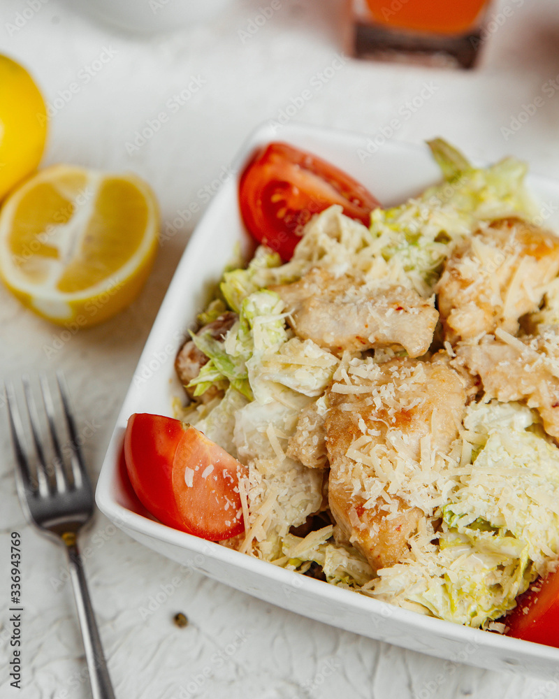 close up of caesar salad with chicken lettuce tomato parmesan