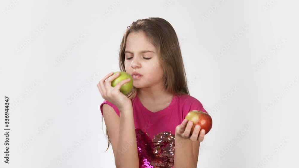 Girl with an Apple. Little girl eating an Apple Girl in a pink bright dress on a white background. Girl with an Apple. Little girl eating an Apple Girl in a pink bright dress on a white background.