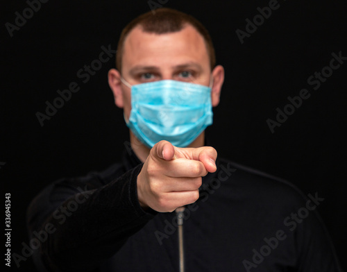 man points a finger at a patient in a medical mask