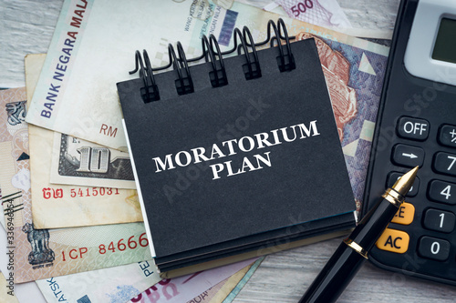 Obraz na płótnie MORATORIUM PLAN text with fountain pen, calculator, currency banknotes and notepad on wooden background