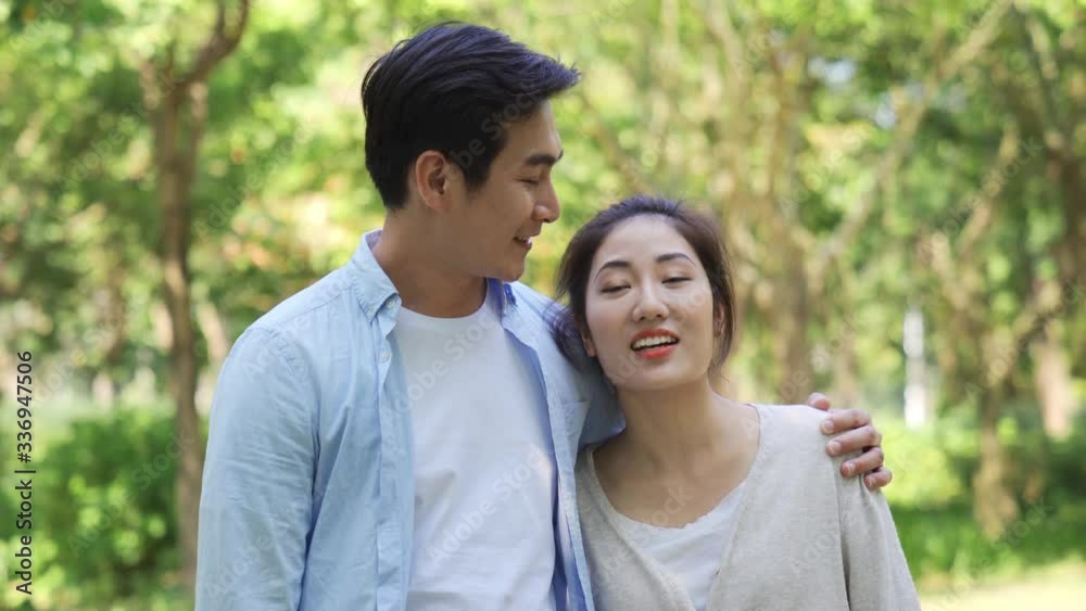 loving young asian couple taking a walk outdoors in park loving young asian couple taking a walk outdoors in park