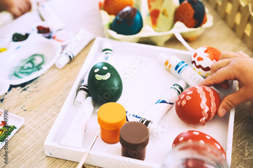 Children painting eggs. Family preparing for Easter.