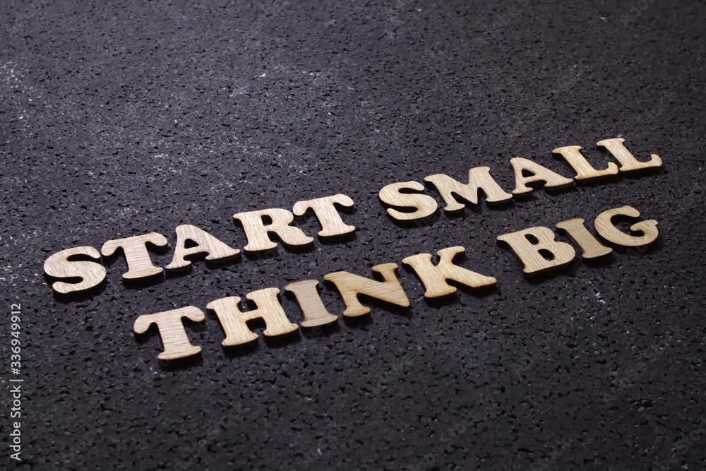 Fototapeta premium Start small think big, business motivational inspirational quotes; wooden words typography lettering concept