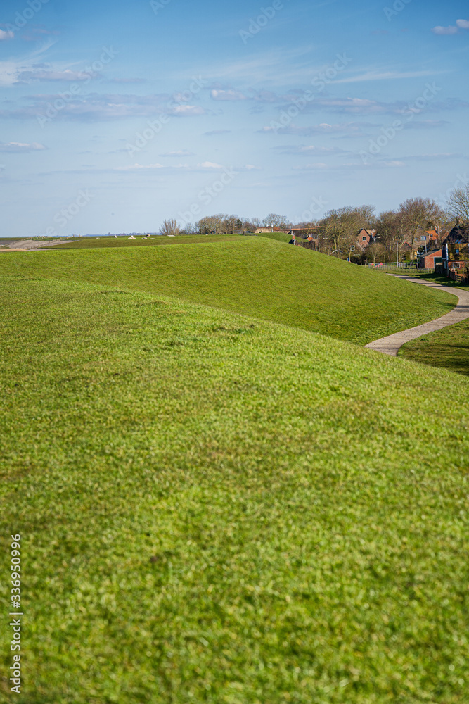 Fototapeta premium Cultivated Dutch dike landscape along the Wadden Sea in the north of Holland