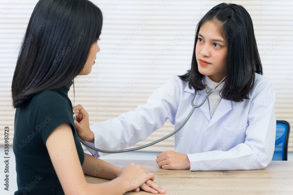 Young Asian female doctor uses the stethoscope to examine and diagnose adult female patient’s sickness and symptom. Medicine and health care concept. Doctor and patient. Young Asian female doctor uses the stethoscope to examine and diagnose adult female patient’s sickness and symptom. Medicine and health care concept. Doctor and patient.