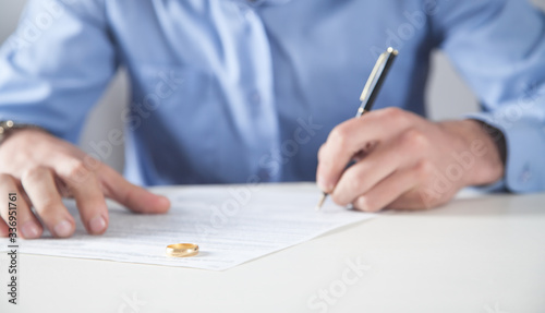 Man with divorce contract and ring on desk. Divorce