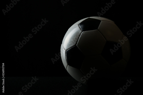 football ball with shadow on black background with copy space
