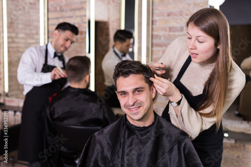 Male getting haircut by professional hairdresser