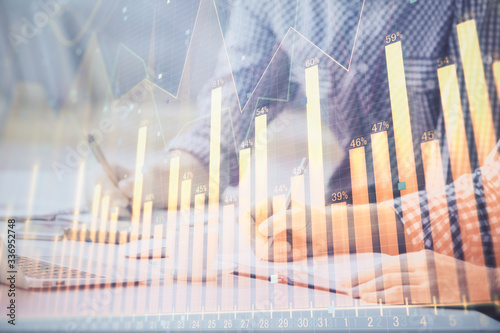 Multi exposure of forex chart with man working on computer on background. Concept of market analysis.