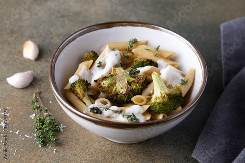 Whole grain penne pasta with broccoli and creamy sauce. Healthy lunch dish